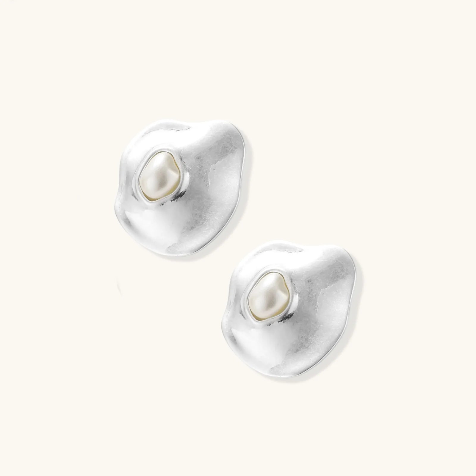 Organic-shaped eco-zinc alloy stud earrings with resin pearl centers and sterling silver posts on white background.