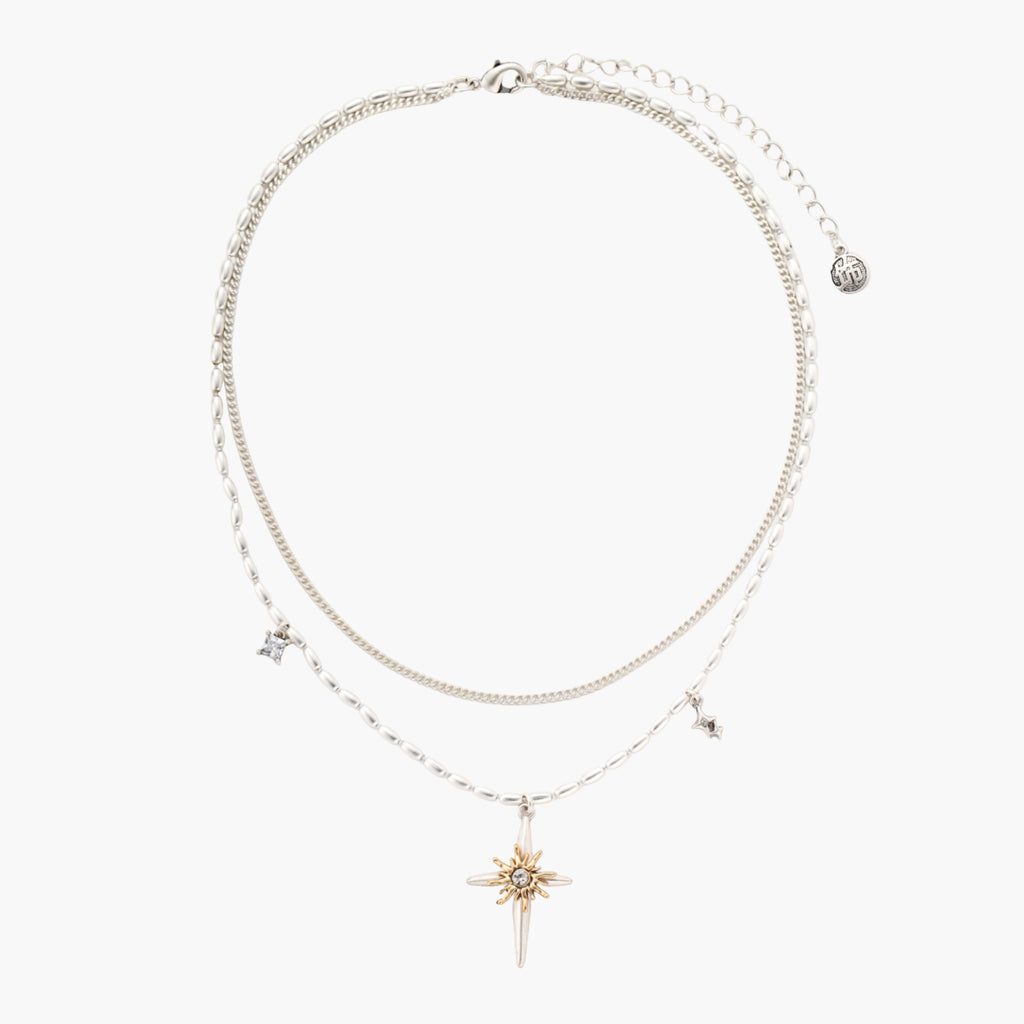 Two-layer silver-toned necklace with star charms and dagger pendant featuring golden sun motif on white background.