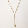 Adjustable gold lariat necklace with freshwater pearls nested in delicate cage settings and Y-shaped tassel drop