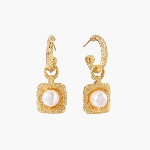 Pair of gold vermeil hoop earrings with textured square frames holding freshwater pearls on cream background