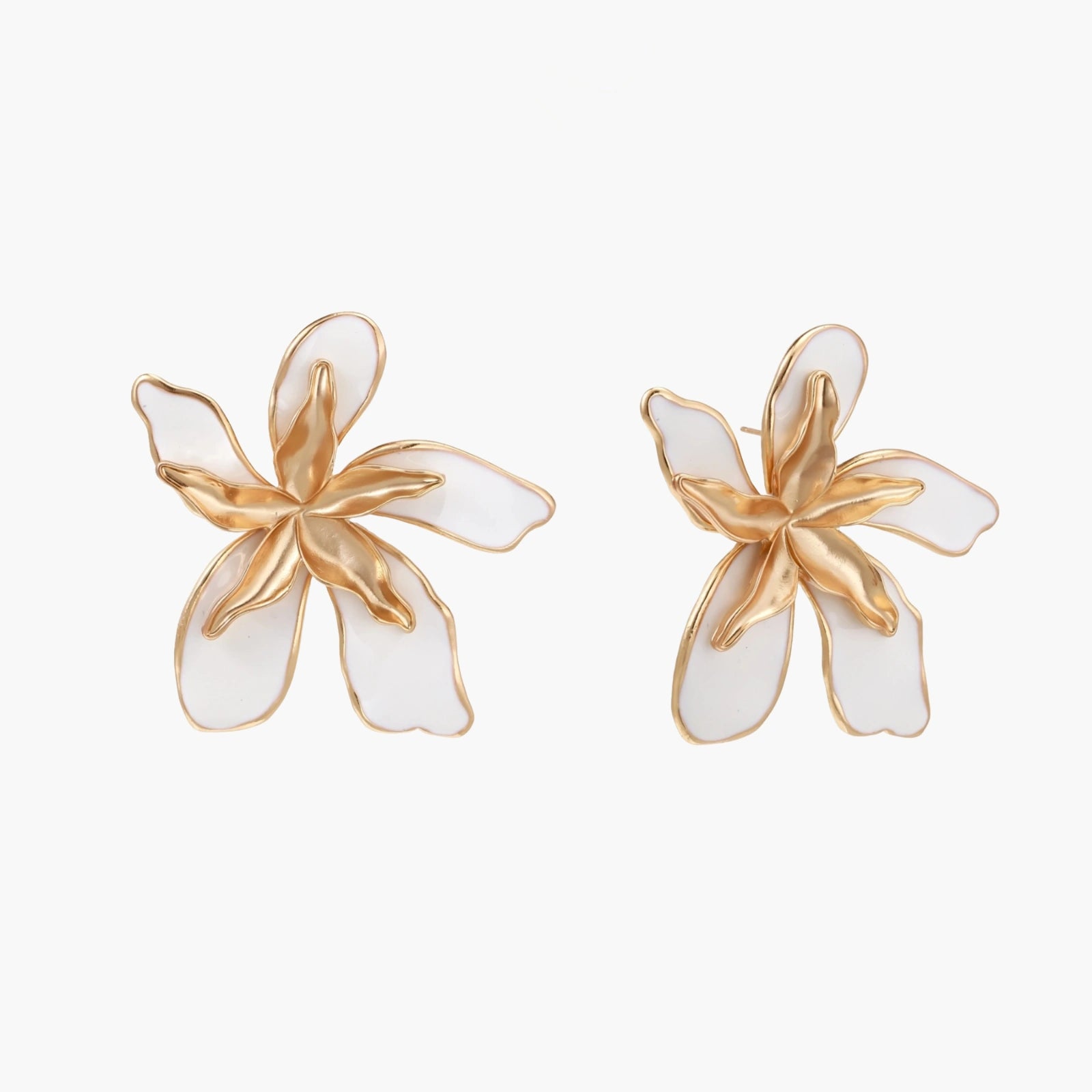 White enamel tropical flower earrings with sculptural gold-plated center and organic petal design on cream background