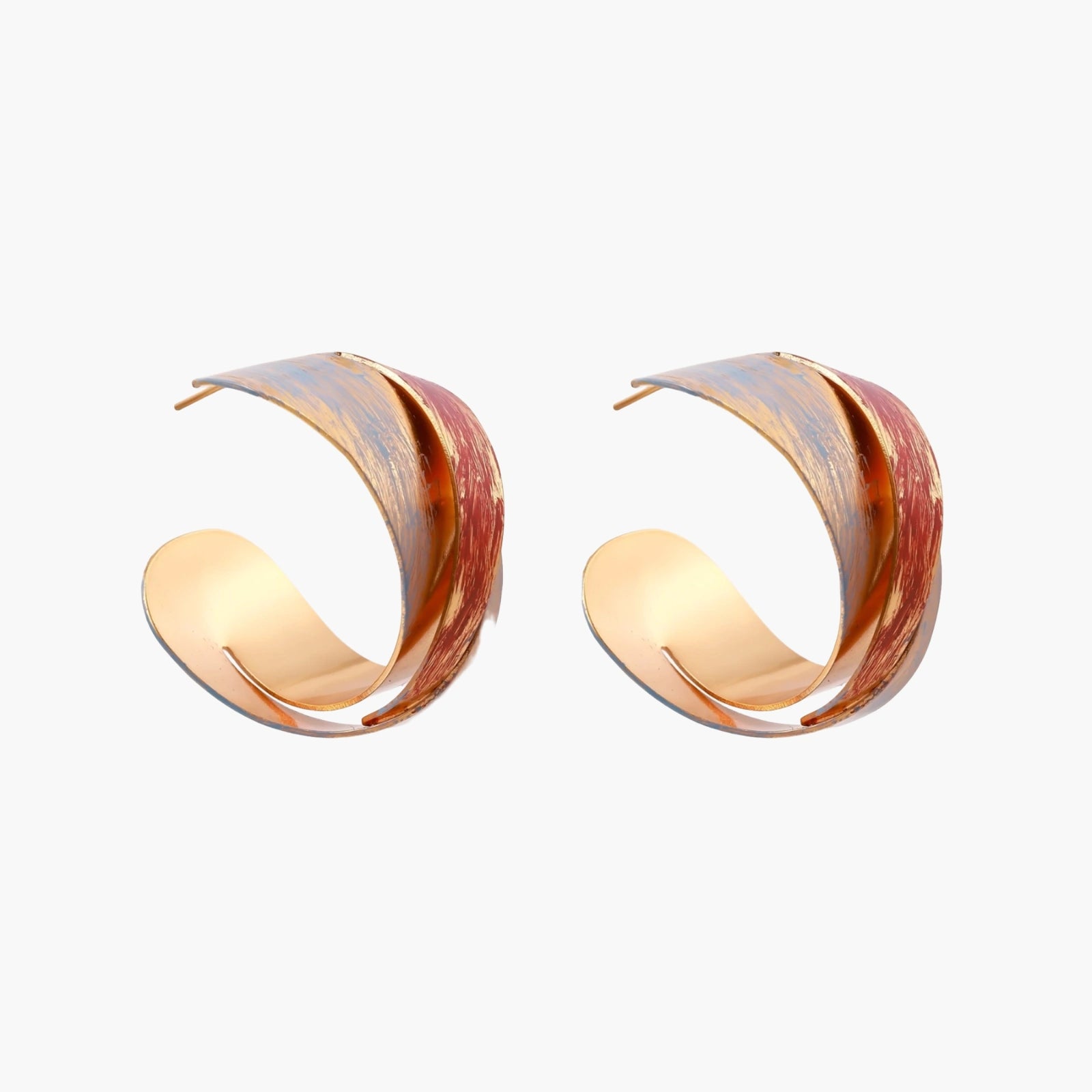 Sculptural gold-plated hoop earrings with diagonal purple and coral enamel stripes in twisted ribbon design