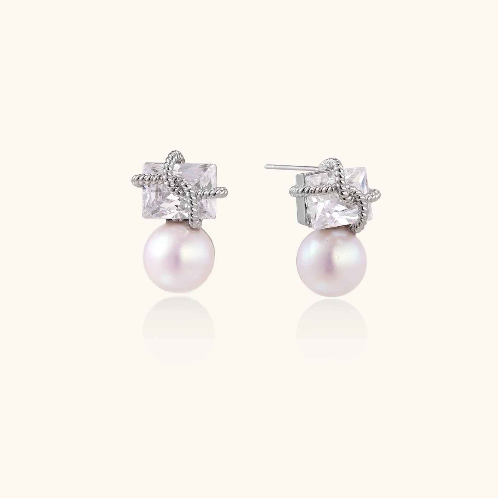 White gold stud earrings with square crystal stones in twisted frames and pink freshwater pearl drops below