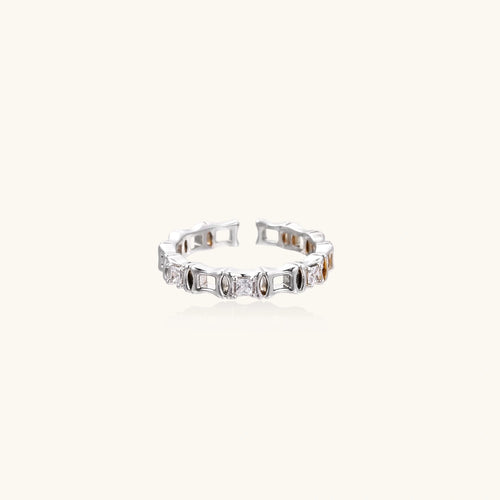 White gold plated ring with architectural lattice design and zirconia accents on cream background
